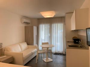 a living room with a couch and a table at AppartArbus white suite in Arbus +12 photos