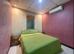ein Schlafzimmer mit einem grünen Bett und einem Fenster in der Unterkunft Village House CAC 2 in Strand Bang Tao