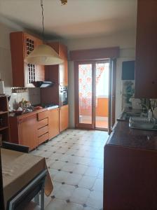 eine Küche mit einer großen offenen Tür zu einer Terrasse in der Unterkunft Sicilia vacanze long beach Mondello in Palermo