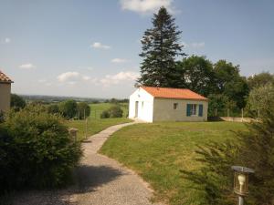 una pequeña casa blanca en una colina con un camino en M. Clemenceau - Les Maisonnettes De La Maneliére, en La Flocellière