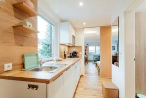 a kitchen with a sink and a large window at Chalet-Apartment Seefeld and Chill HARMONY im Zentrum mit Netflix for free in Seefeld in Tirol