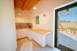 a kitchen with a counter and a large window at Il Fiore della Vita Trulli Country house in Conversano +22 photos