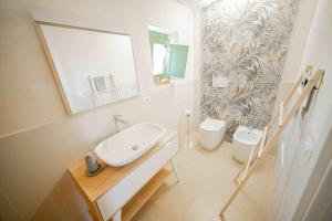 a bathroom with a sink and a mirror and a toilet at Il Fiore della Vita Trulli Country house in Conversano