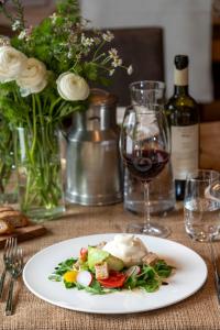 um prato de comida numa mesa com um copo de vinho em Agriturismo Rini em Bormio