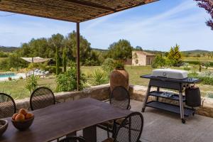 a grill on a patio with a table and chairs at Vista Verde in Sineu