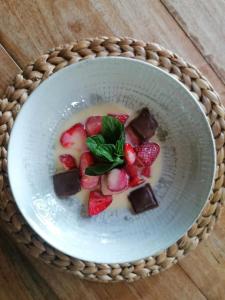 un bol de chocolat et de fraises sur une table dans l'établissement Le Clos de La Chardonnière, à Saulce-sur-Rhône