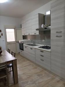 una cucina con lavandino e piano cottura forno superiore di Aledò, casa vacanze a Casalabate