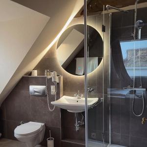 a bathroom with a sink and a shower and a toilet at Hotel van Bebber in Xanten