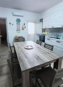 una cucina con tavolo e sedie in legno di Aledò, casa vacanze a Casalabate