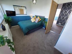 a living room with a blue couch and a mirror at Perfect Cowes retreat with Hot Tub in Cowes