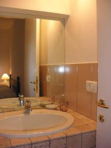a bathroom with a sink and a large mirror at B&B Il Gatto Pescatore in Stintino