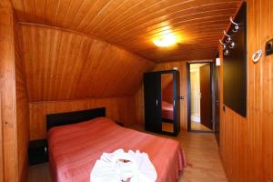 ein Schlafzimmer mit einem Bett in einem Holzzimmer in der Unterkunft Casa Teodora Rânca in Ranca