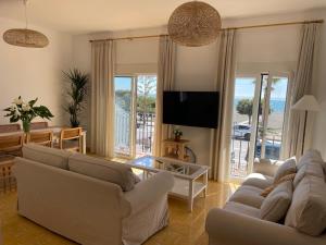 Sala de estar con 2 sofás y TV en Casa Julia Apartamento Playa Benajarafe, en Vélez-Málaga