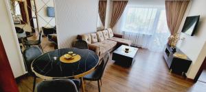 a living room with a table and a couch at JAG apartamentai miesto centre in Šiauliai