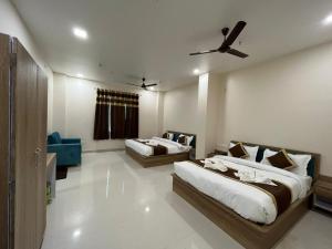1 dormitorio con 2 camas y sofá azul en HOTEL KAVANA, en Varanasi