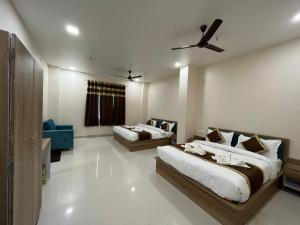 a bedroom with two beds and a blue couch at HOTEL KAVANA in Varanasi