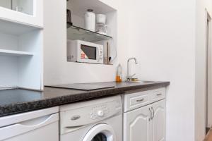 - une cuisine blanche avec lave-linge et sèche-linge dans l'établissement Modern 1BR Apart- Suitable for Longstays, à Vienne