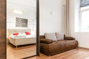 - un miroir dans une chambre avec un lit et un canapé dans l'établissement Modern 1BR Apart- Suitable for Longstays, à Vienne