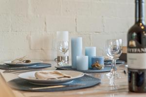 una mesa con platos y copas y una botella de vino en Zeeanemoon - Holiday home for 6 persons, en Middelkerke