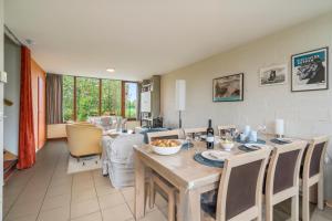 een eetkamer en een woonkamer met een tafel en stoelen bij Zeeanemoon - Holiday home for 6 persons in Middelkerke