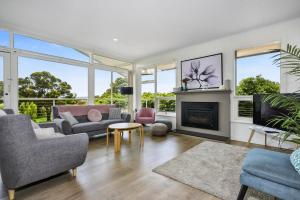 a living room filled with furniture and a fireplace at Modern Beach House - Dromana in Mornington