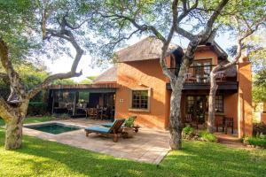 a house with a patio and a pool at Braai Safaris Lodge in Hoedspruit