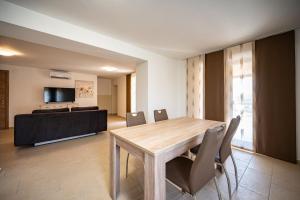a dining room with a wooden table and chairs at Apartman Vito in Pomer