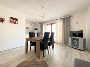 a dining room with a wooden table and black chairs at Apartment Almira with sea view in Krk