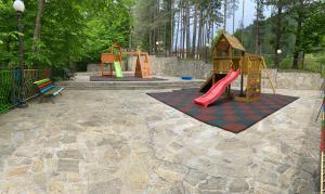 a playground with a slide and a play set at Balkan Hotel in Chiflik