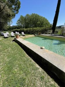 a swimming pool with lounge chairs in a yard at Chateau Talaud in Loriol-du-Comtat