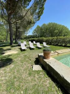 una fila de sillones blancos junto a una piscina en Chateau Talaud, en Loriol-du-Comtat
