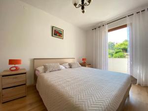 Un dormitorio con una cama grande y una ventana en Apartment Almira with sea view en Krk