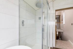 a bathroom with a shower with a glass door at Fallow Cottage in Lyndhurst +22 photos