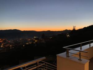 a view of the sunset from the balcony of a building at AppartArbus white suite in Arbus
