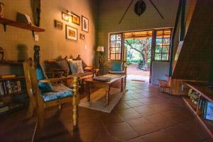 een woonkamer met een bank en een tafel bij Braai Safaris Lodge in Hoedspruit
