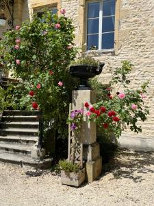 a bird bath in front of a building with flowers at Chateau Du Four De Vaux in Varennes Vauzelles