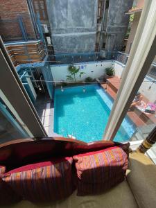 a view of a swimming pool from a window with a couch at Alobar1000 Hostel in Kathmandu