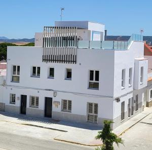 - un bâtiment blanc avec un balcon au-dessus dans l'établissement Apartamento nuevo en Primera Planta A con Piscina, à Barbate