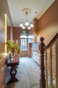 pasillo con escalera y mesa con planta en Topper's Rooms Guest Accommodation, en Carrick on Shannon