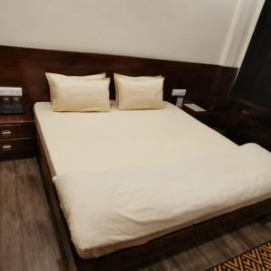 a large white bed with two pillows on it at Kafal Gates in Lansdowne