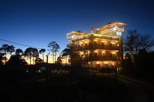 a lit up building with lights on it at night at Kafal Gates in Lansdowne