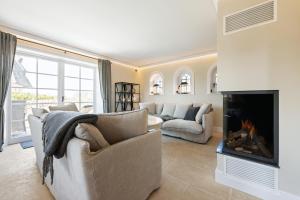 a living room with a couch and a fireplace at Ferienhaus Miarwuefki in Rantum