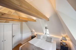 um quarto com uma cama branca e tectos em madeira em Ferienhaus Miarwuefki em Rantum