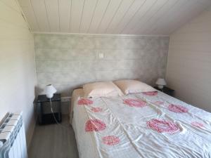 1 dormitorio con 1 cama y 2 mesitas de noche con lámparas en M. Clemenceau - Les Maisonnettes De La Maneliére, en La Flocellière