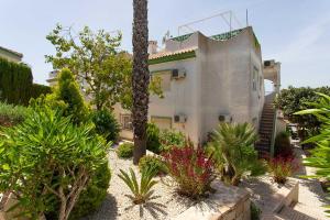 a house with a lot of plants in front of it at CH Buganvillas Ciudad Quesada in Ciudad Quesada