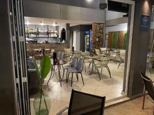 un restaurante con mesas y sillas y un bar en Hotel Evagelia, en Leptokarya