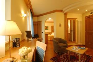 uma sala de estar com uma mesa e um quarto com uma cama em Hotel Lido - green & slow life em Molveno