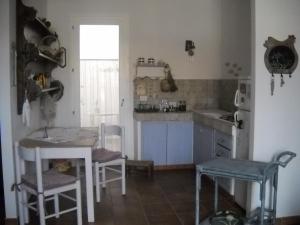 a kitchen with a table and chairs and a sink at B&B Il Gatto Pescatore in Stintino