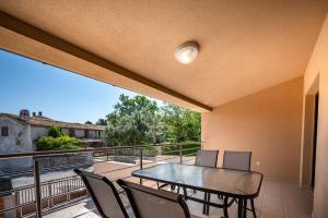 a patio with a table and chairs on a balcony at Apartman Vito in Pomer