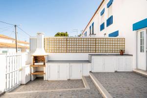 a garage with white doors and a fence at Casa Alto da Serra Sesimbra in Sesimbra